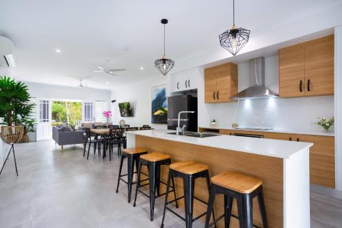 a kitchen and living room with a bar with stools at 5 Star Villa in Tropical location with Patio and Hot Tub 3 bedroom 2 Bath in Edge Hill