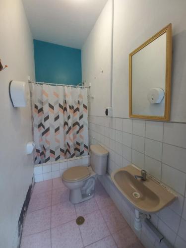 ein Badezimmer mit einem WC, einem Waschbecken und einem Spiegel in der Unterkunft El Boquerón - Hospedaje in Huanchaco