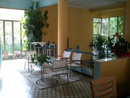 a room with chairs and a table and windows at Hotel Athena in Pesaro