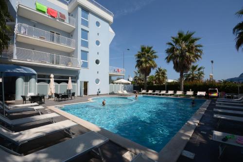 a swimming pool in front of a hotel at Kiara Residence in Giulianova
