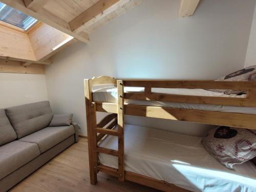 a bedroom with a bunk bed and a couch at Appartement Les Gets, 3 pièces, 5 personnes - FR-1-598-162 in Les Gets