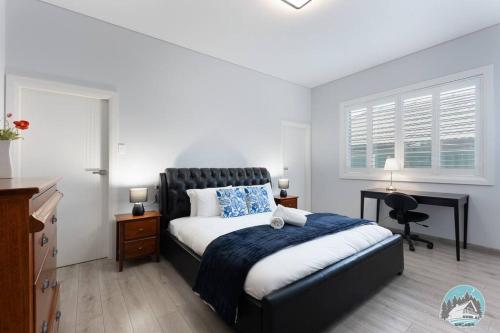 a bedroom with a bed and a desk and a window at Aircabin - Fairfield - Modern - 6 Bedrooms House in Fairfield