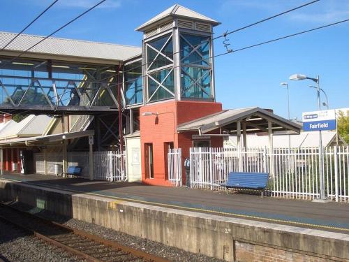 a train station with a blue bench on the platform at Aircabin - Fairfield - Modern - 6 Bedrooms House in Fairfield