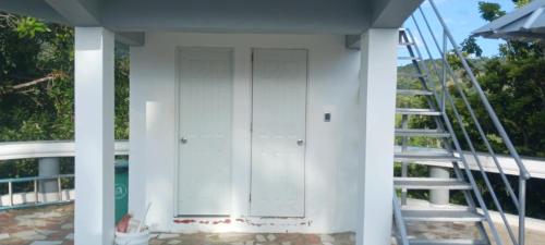 a white door on a house with a staircase at villa almonte in Santiago de los Caballeros