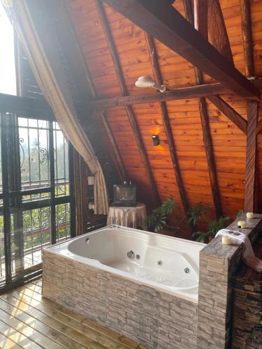 a large bath tub in a room with wooden ceilings at GLAMPING MILAGROS in San Pedro