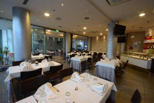 a dining room with white tables and chairs at Kiara Residence in Giulianova