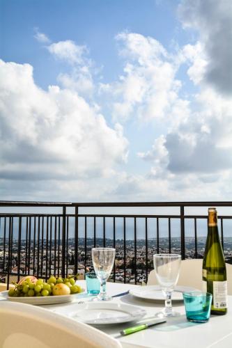 einen Tisch mit einer Flasche Wein und Gläsern auf dem Balkon in der Unterkunft Peyia Pearl in Peyia