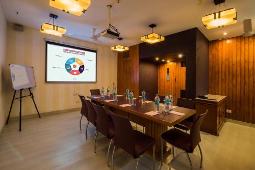 a conference room with a long table and chairs and a screen at Home@F37 Kailash Colony Metro in New Delhi