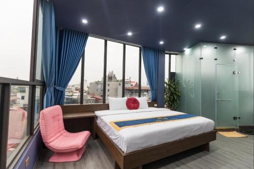 1 dormitorio con 1 cama y 1 silla rosa en Light House & Rooftop en Hanoi