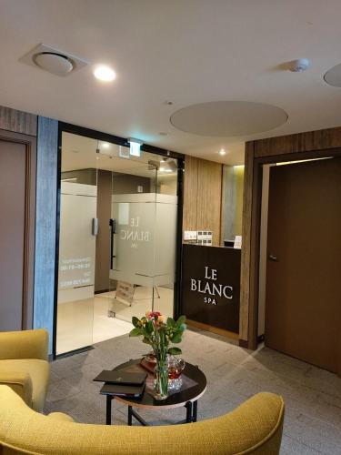 a lobby with a table and chairs and a sign at Sweet May Seogwipo Hotel in Seogwipo