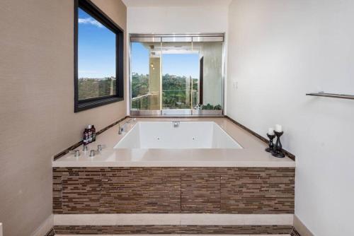 a large bath tub in a room with a window at Spectacular Views: Exquisite Villa, Pool, Jacuzzi! in Los Angeles