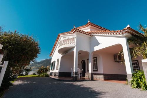 a white house with a driveway at GuestReady - Peaceful Paradise in Madeira in Arco da Calheta
