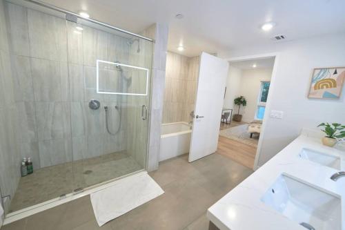 La salle de bains est pourvue d'une douche et de 2 lavabos. dans l'établissement Hidden Gem in LA: Stylish Haven, à Los Angeles