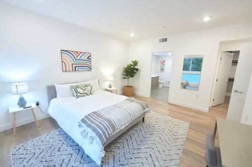 - une chambre blanche avec un lit et un tapis dans l'établissement Hidden Gem in LA: Stylish Haven, à Los Angeles