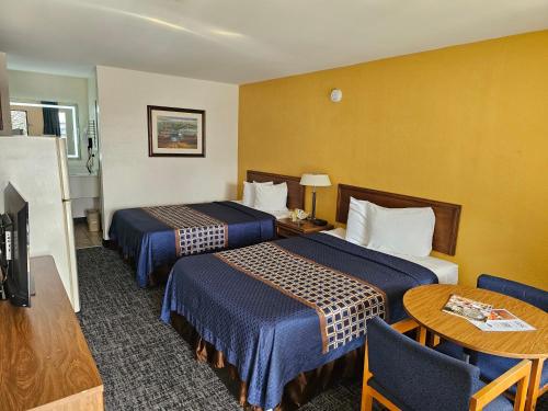 Habitación de hotel con 2 camas y mesa en Bluegrass Extended Stay, en Lexington