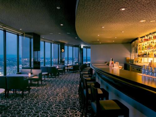 a restaurant with a bar with a view of the city at Shin Yokohama Prince Hotel in Yokohama