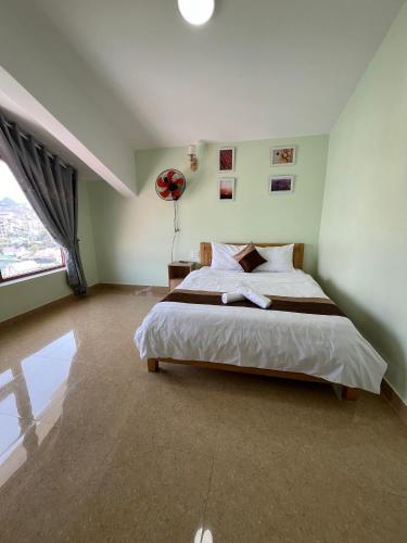 a bedroom with a large bed and a large window at Alex Home Đà Lạt in Da Lat