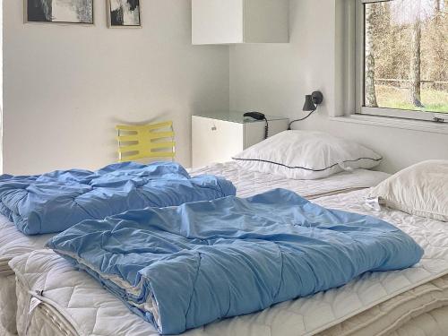 two beds with blue sheets on them in a bedroom at Holiday home Væggerløse LX in Marielyst