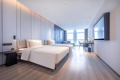 um quarto de hotel com duas camas e uma secretária em Atour Hotel Jinan Huashan Huanyu Max em Jinan