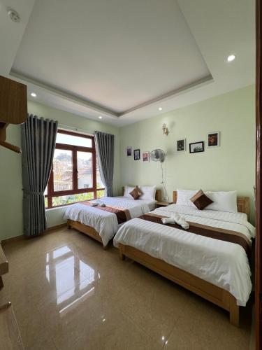 a bedroom with two beds and a window at Alex Home Đà Lạt in Da Lat