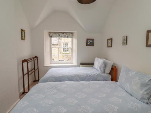 a bedroom with two beds and a window at Avocet Cottage in Bamburgh