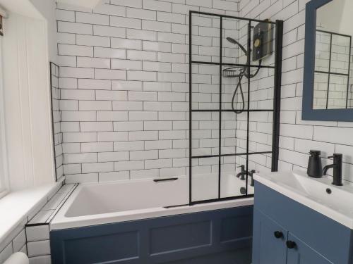 a bathroom with a tub and a sink at Avocet Cottage in Bamburgh