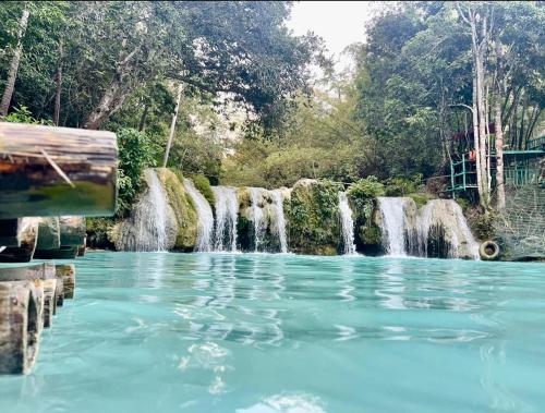 uma piscina de água em frente a uma cascata em Fumiko Rina Acop em San Juan