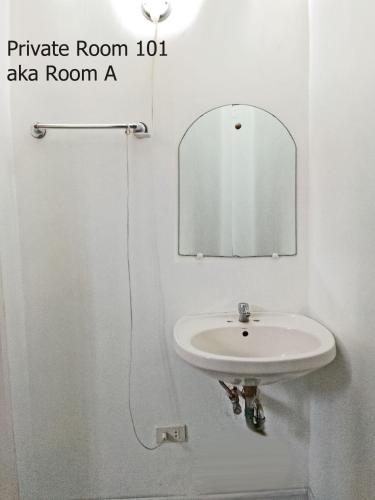 a white sink in a bathroom with a mirror at Leizel's Bed & Breakfast in Palompon