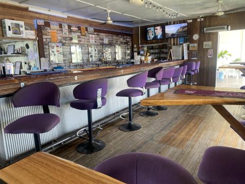 a bar with purple bar stools in a restaurant at Carmila Hotel in Carmila