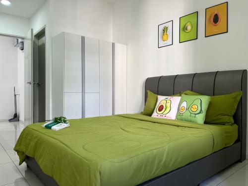 a bedroom with a bed with a green comforter at C&Y Horizon Suites Homestay Sepang - KLIA Transit - Near XiaMen University in Kampong Melot