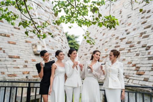 a group of women in white suits standing in front of a building at The Coffee City - Healing & Retreats in Buon Ma Thuot