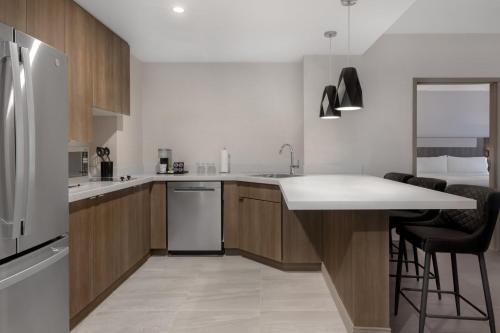 a kitchen with wooden cabinets and a white refrigerator at Holiday Inn Express & Suites St Thomas in Saint Thomas