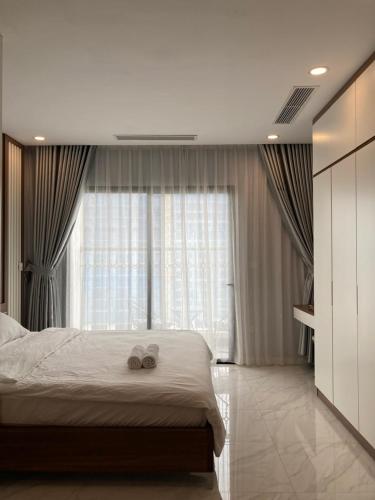 a bedroom with a bed with two wedding shoes on it at Luxury econest - Apartment with swimming pool & gym in Hanoi