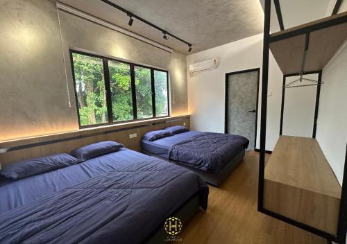 two beds in a room with two windows at The Luxurious 27, Johor Bahru in Johor Bahru