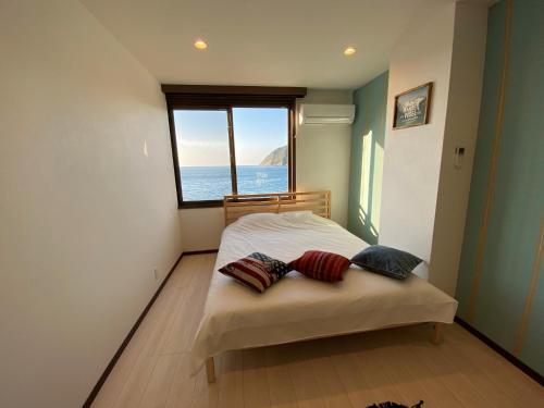 a bedroom with a bed with a view of the ocean at seaside villa HILIFE - Vacation STAY 99018 in Kogushi