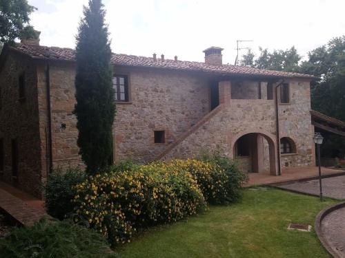 une vieille maison en pierre avec un jardin et un arbre dans l'établissement Ferienhaus für 10 Personen und 4 Kinder in Chianni, Toskana Provinz Pisa, à Rivalto