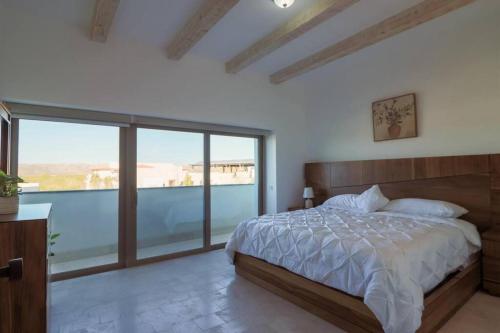 sypialnia z łóżkiem i dużym oknem w obiekcie Villa Parvada w mieście Parras de la Fuente