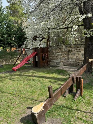 un parque con un parque infantil con un tobogán rojo en Cetatuia en Măgura