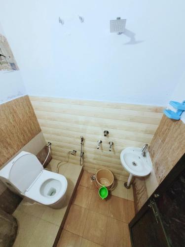 a bathroom with a toilet and a sink at Pushpa Vatika in Faizābād