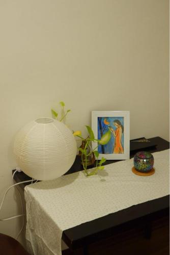 un tavolo con una lampada e un quadro sopra di La Sen - Đông Thì a Hương Trà