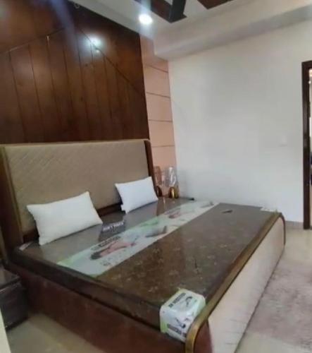 a bed in a room with a table at Baidwan’z 120/c in Zirakpur