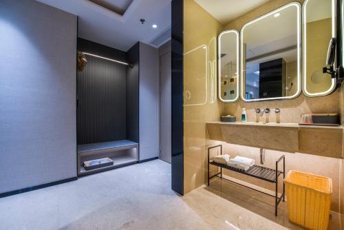 bagno con lavandino e specchio di Atour S Hotel Guangzhou Zhujiang Taikoocang a Canton