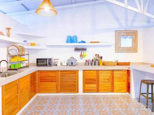 a large kitchen with wooden cabinets and a sink at Villa Ameda Homestay @ Sg Sembilang in Jeram