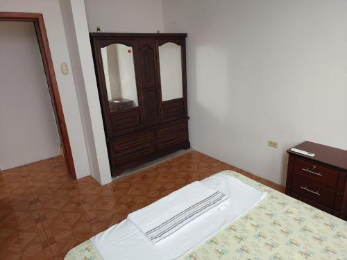 a bedroom with a bed with a dresser and a mirror at Departamentos de la Costa in Machala