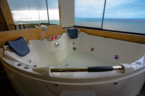 a bath tub with a view of the ocean at Golden Mar Hotel in Lima