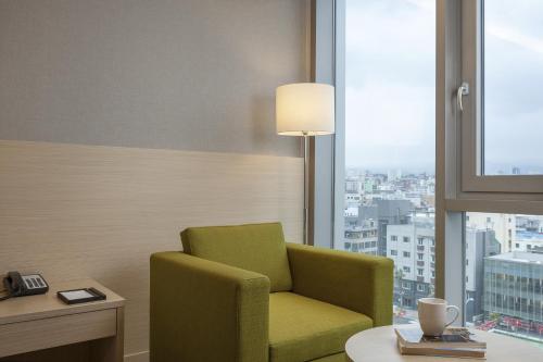 a green chair in a room with a window at Hotel Regent Marine The Blue in Jeju