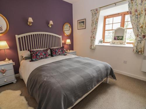 a bedroom with a large bed and a window at The Garden House in Chirnside