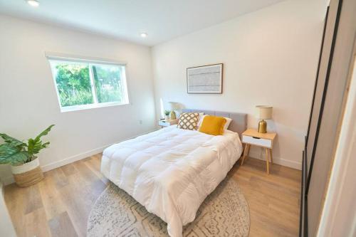 Un dormitorio blanco con una cama grande y una ventana en Luxury at its Finest in Larchmont W. Roof Deck, en Los Ángeles