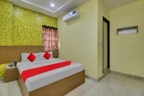 a bedroom with a bed with red pillows and a window at Flagship Hotel Abhi's R Square Near Hayathnagar in Pedda Ambarpet