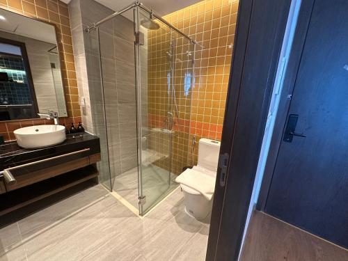 a bathroom with a shower and a toilet and a sink at Phan Nguyên Mandala Mũi Né in Mui Ne